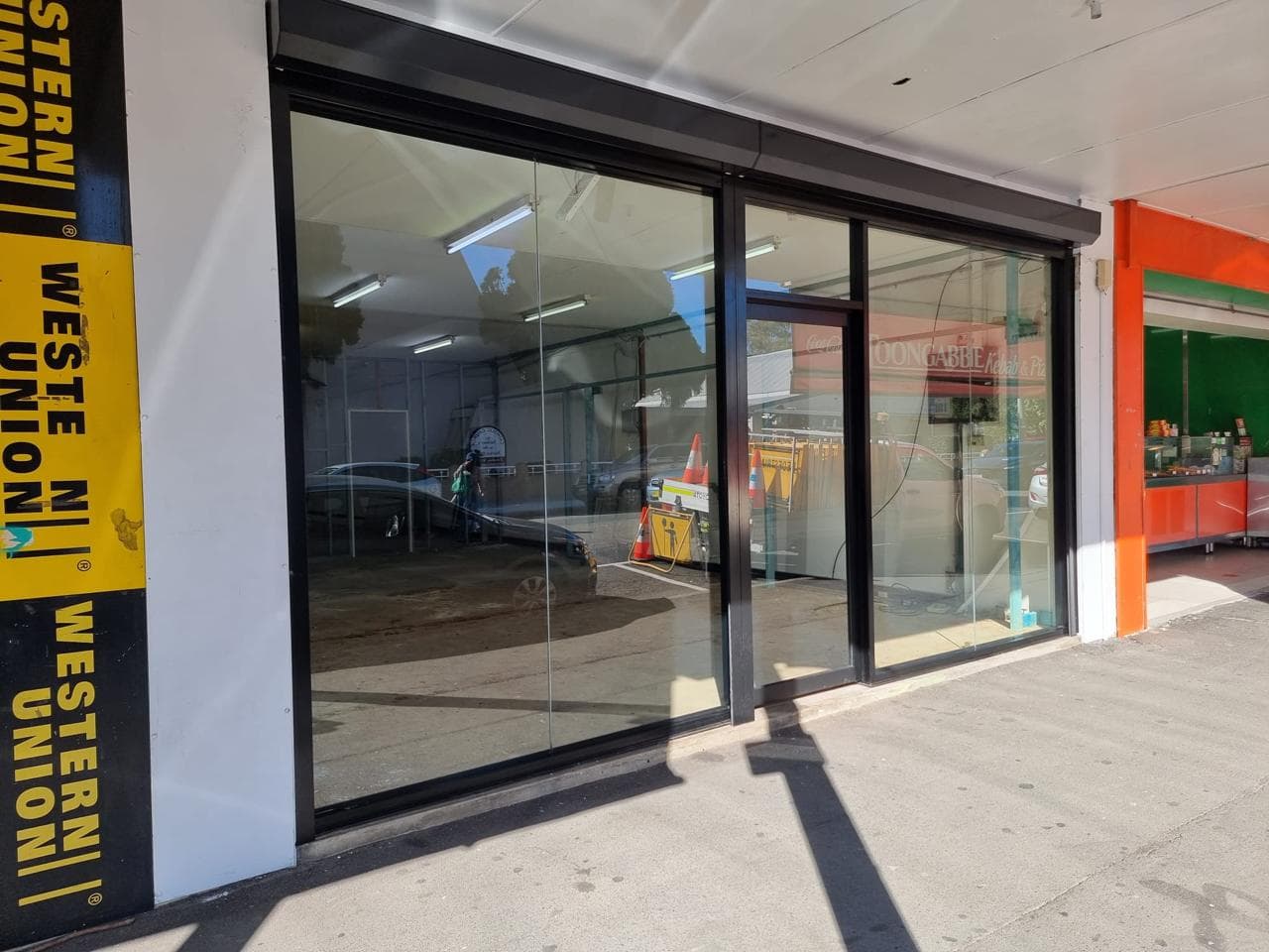 Technician installing commercial glass shopfront door in Sydney — Shop Front Sydney glazing installation service