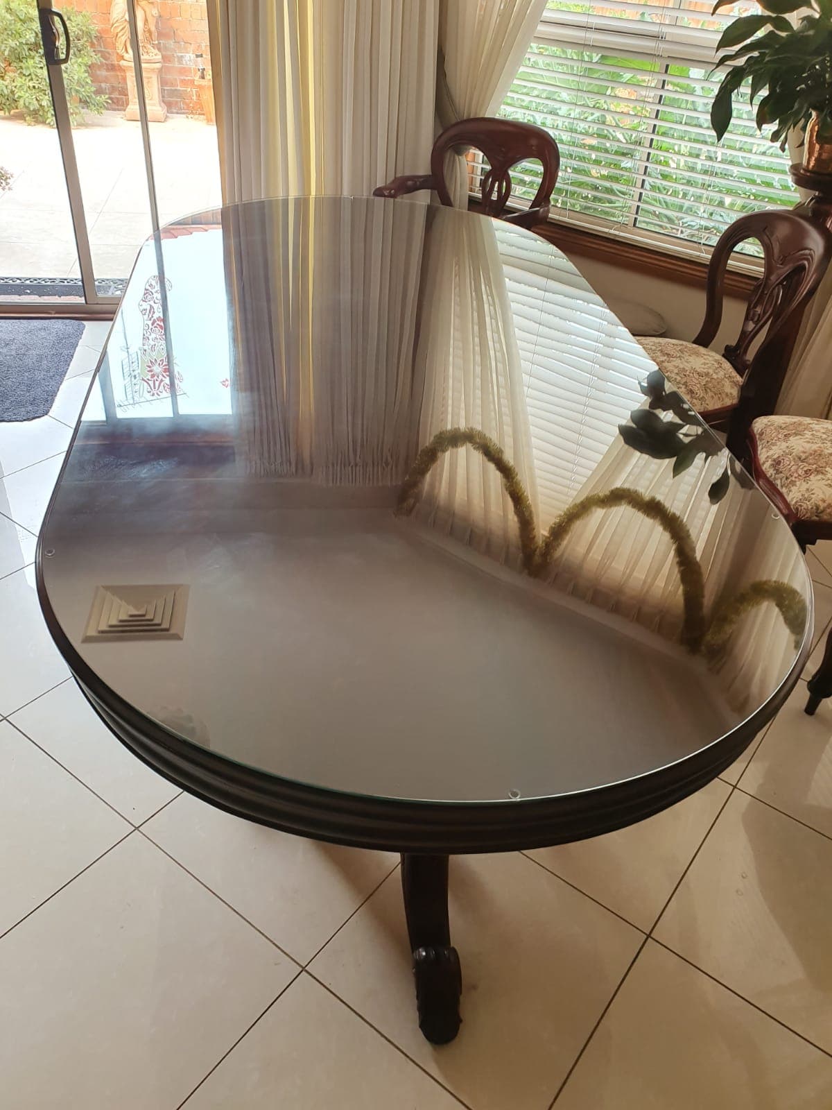 Tinted glass tabletop installation on dining table with polished edge finish