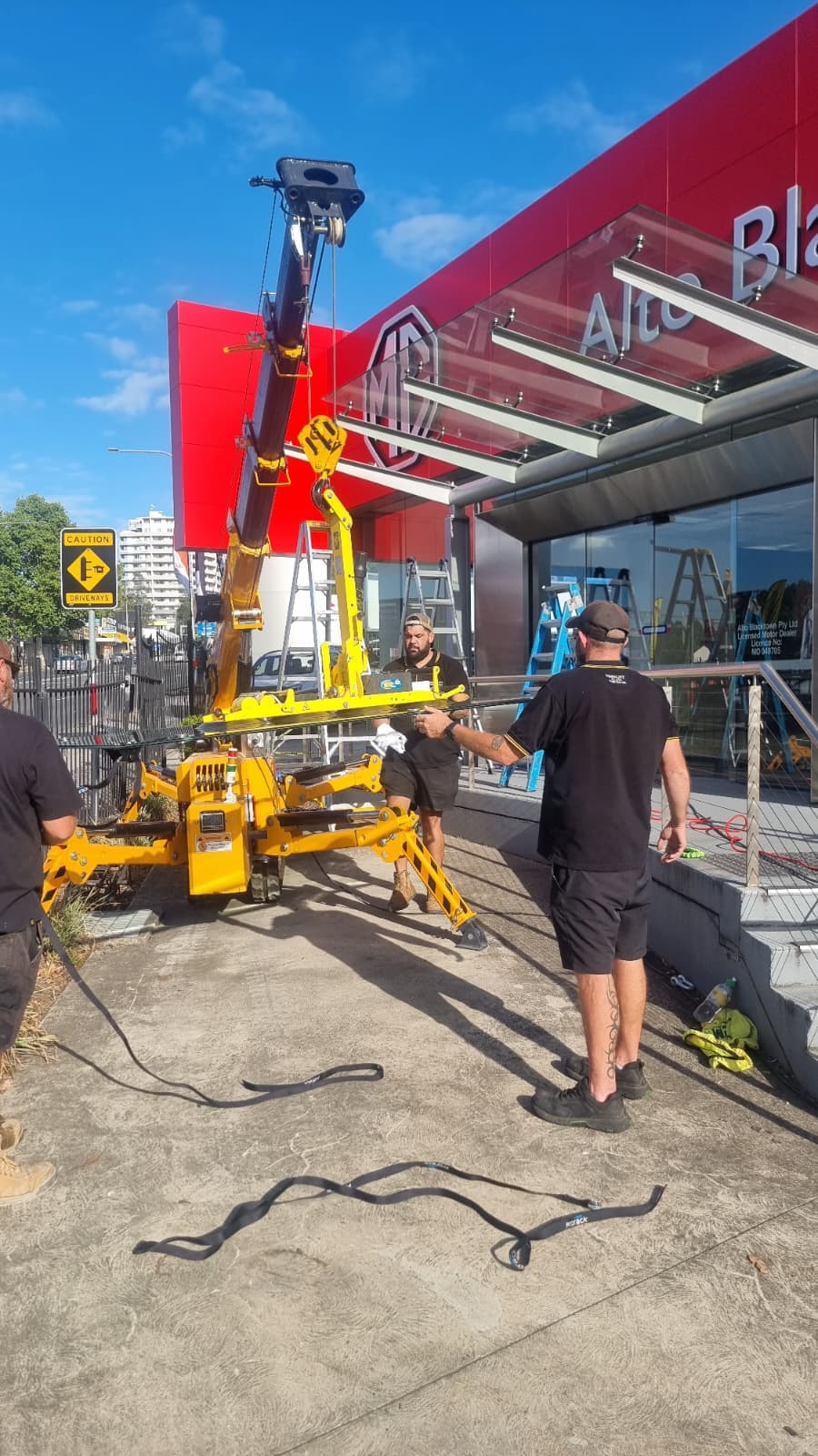 Commercial glass canopy installation using lifting equipment and suction lifter