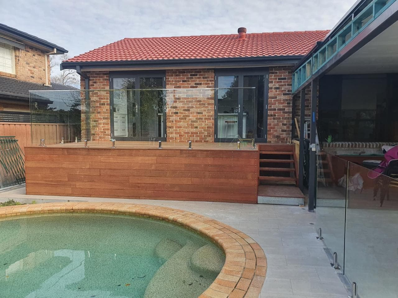 Frameless glass pool fencing surrounding a luxury backyard swimming pool